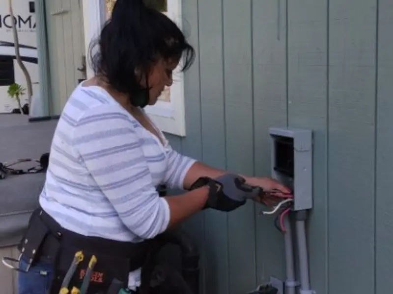 Licensed electrician wiring an exterior subpanel in Lawrence